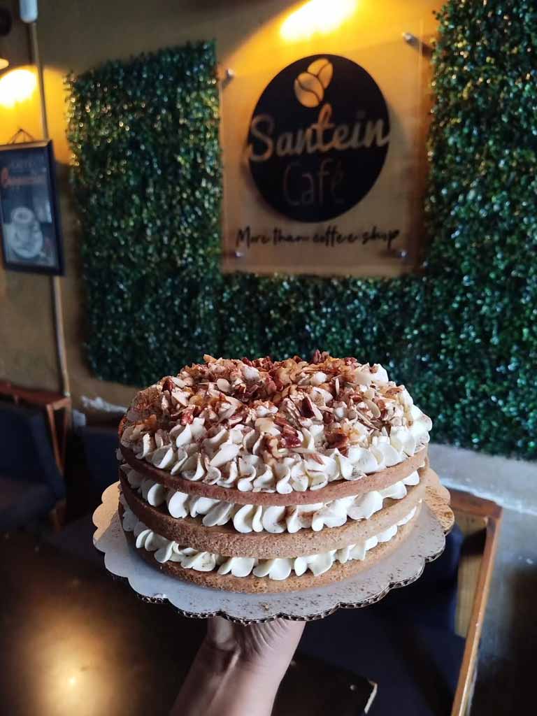 Pastel artesanal de capas decorado con crema y nueces.