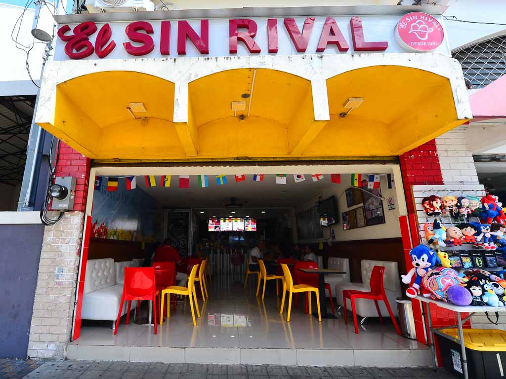 Entrada a la sorbetería El Sin Rival con mesas rojas y amarillas.