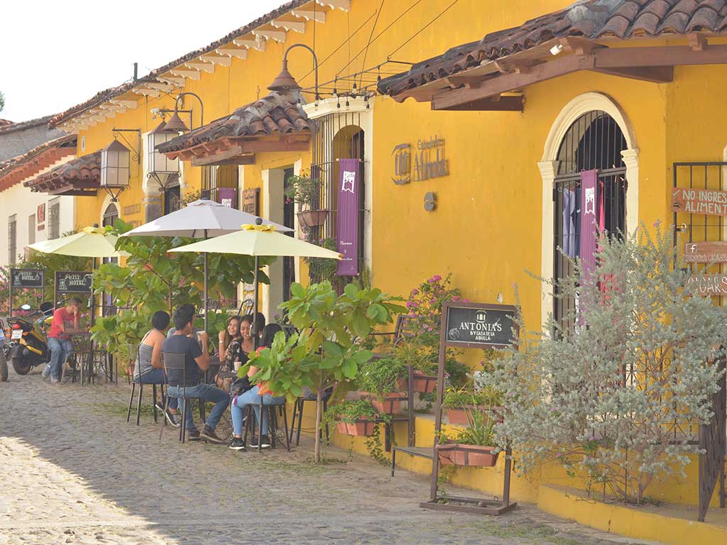 Pareja sentada en una cafetería al aire libre con sombrillas en Suchitoto.