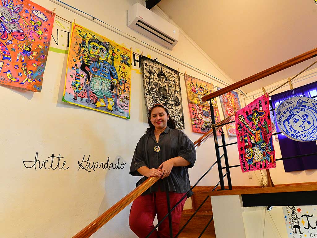 Artista local mostrando sus pinturas en una galería de arte en Suchitoto.