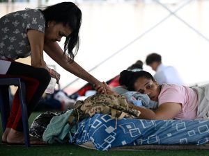 Personas desplazadas por los terremotos del 24 de junio descansan en un campamento improvisado instalado en el complejo deportivo José María Vargas, en Maiquetía, estado La Guaira, Venezuela. AFP