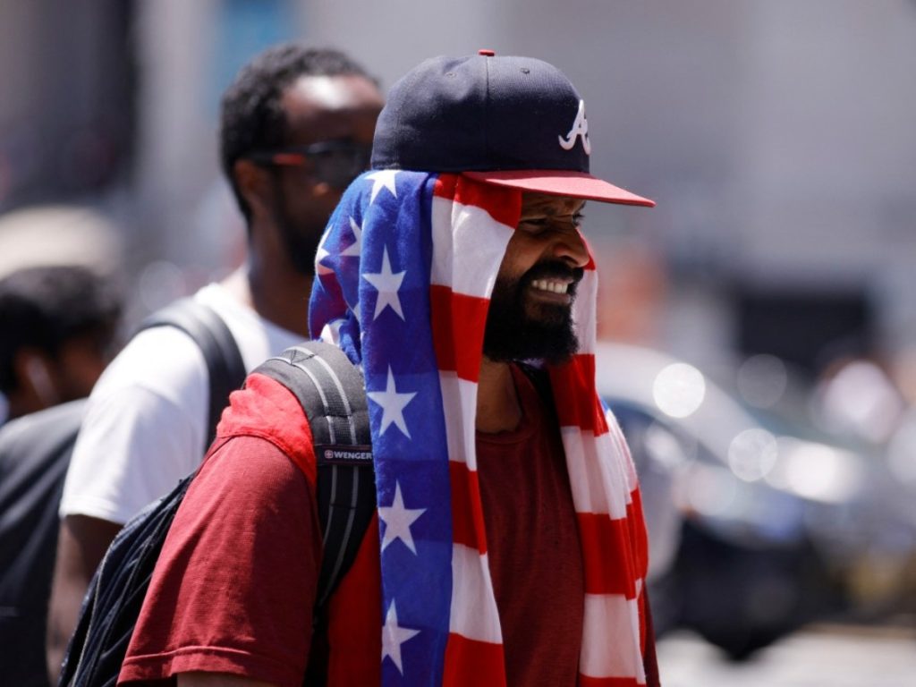 Un hombre se cubre con una toalla con la bandera estadounidense debajo de su sombrero en el centro de Manhattan durante una ola de calor en el marco de las celebraciones del 4 de julio. Foto AFP