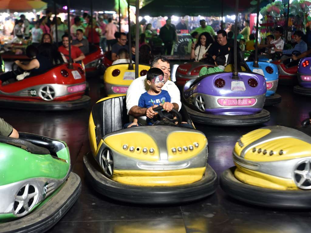 Padre e hijo comparten una sonrisa mientras disfrutan de la diversión en los autos chocones.