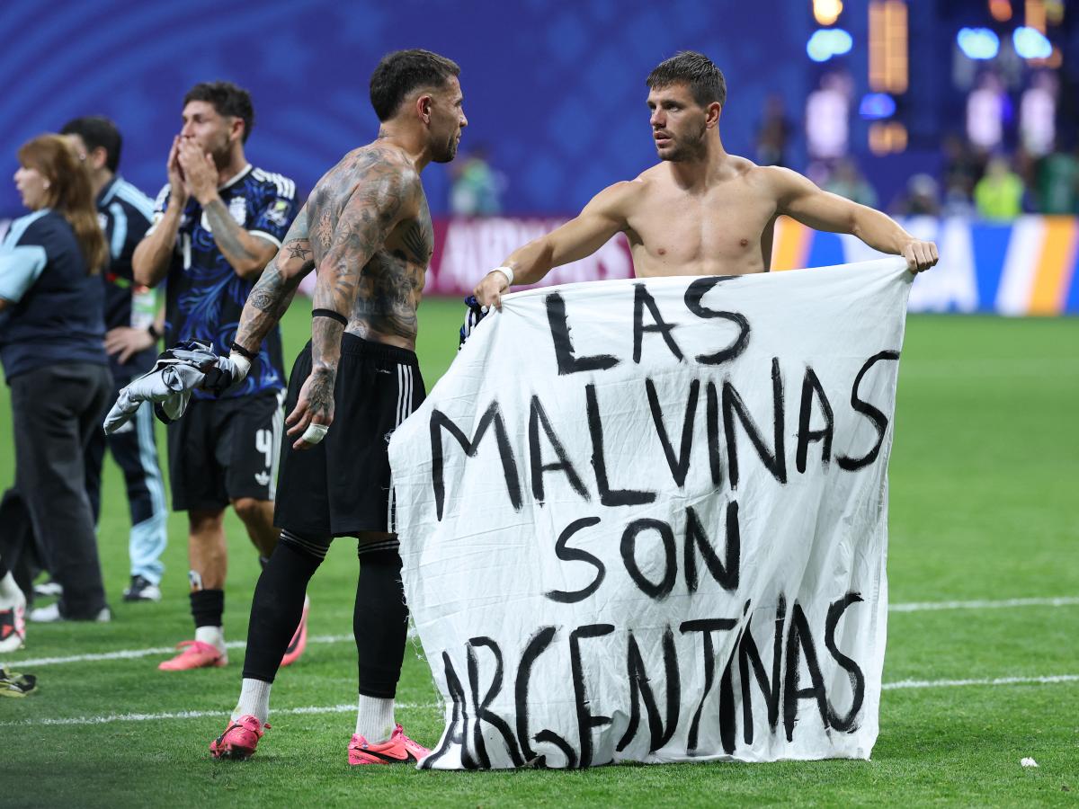 El defensa argentino número 19, Nicolás Otamendi (izquierda), y el mediocampista número 11, Giovani Lo Celso, muestran una pancarta que dice en español: "Las Malvinas (Islas Falkland) pertenecen a Argentina", tras ganar el partido de semifinales del Mundial de Fútbol de 2026 entre Inglaterra y Argentina en el Estadio de Atlanta, el 15 de julio de 2026.