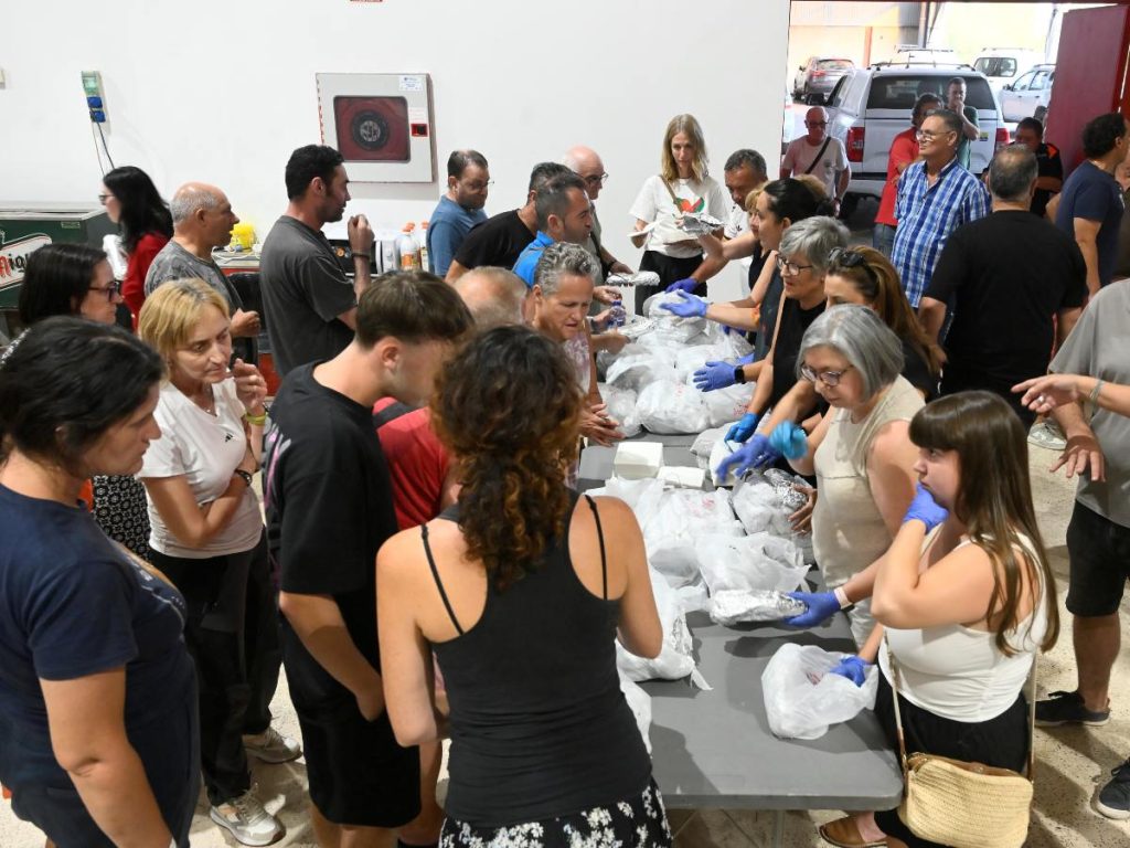 Voluntarios distribuyen alimentos a los evacuados del incendio forestal en el polideportivo de Nules, cerca de Castellón, a 50 km al norte de Valencia, en la tarde del 26 de julio de 2026.
