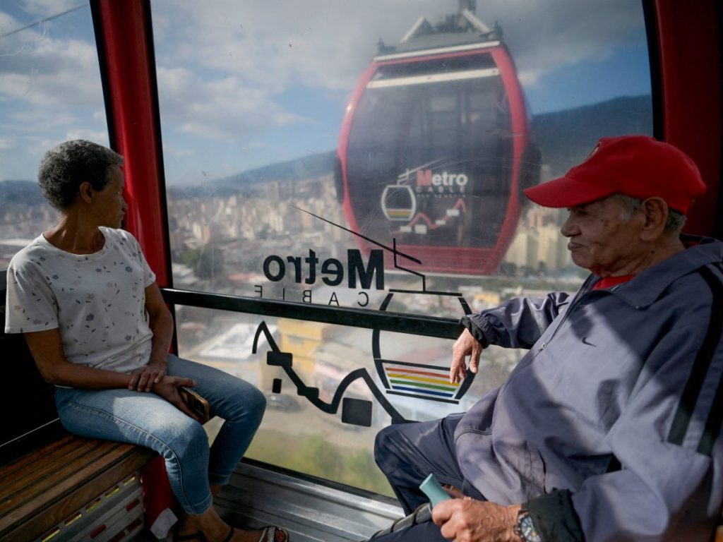 Una pareja viaja en un teleférico del sistema público Metrocable sobre el barrio de San Agustín, en el este de Caracas, el 31 de diciembre de 2025.