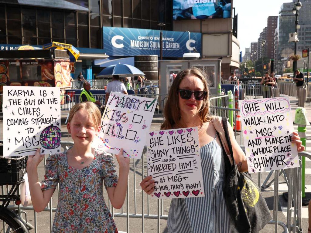 Seguidores de Taylor Swift permanecen frente al Madison Square Garden mientras esperan la llegada de la cantante y los invitados a una de las bodas más comentadas del año.