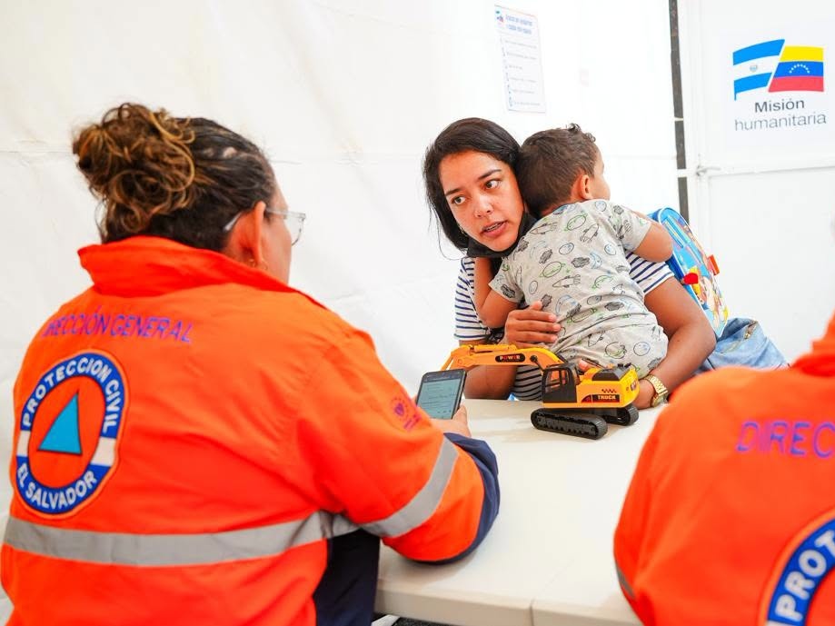 Personal de Protección Civil acompaña a una madre y su hijo durante la atención en el hospital de campaña.