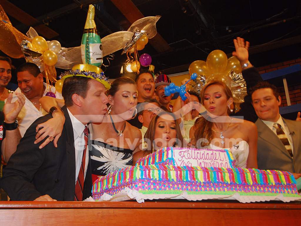 Conductores soplan las velas de un gran pastel.