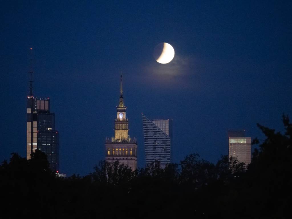 Así se observó en el mundo: la Luna en eclipse parcial se dejó ver en Varsovia mientras caía tras sus rascacielos.