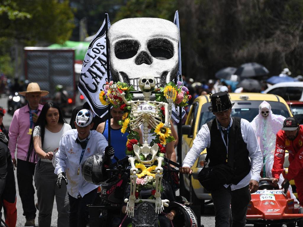 Un vehículo artesanal adornado con la figura de una calavera avanza por la pista ante el entusiasmo del público.