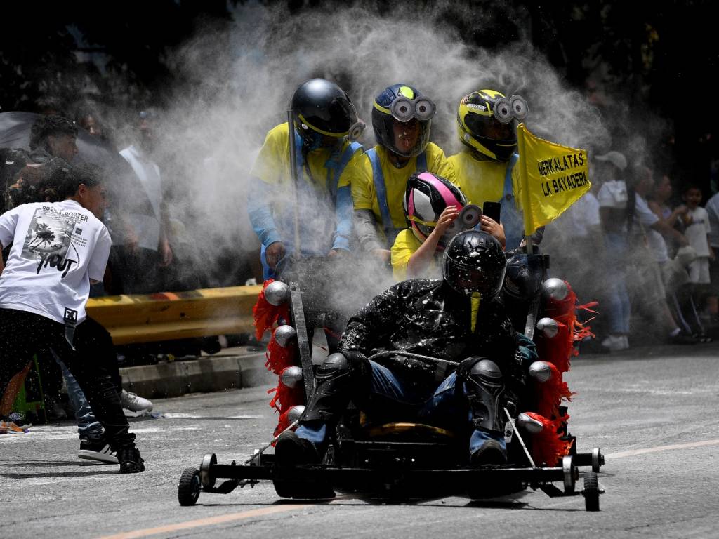 Primer plano de un carro artesanal mostrando sus ruedas recubiertas de caucho sobre el asfalto de la pista.