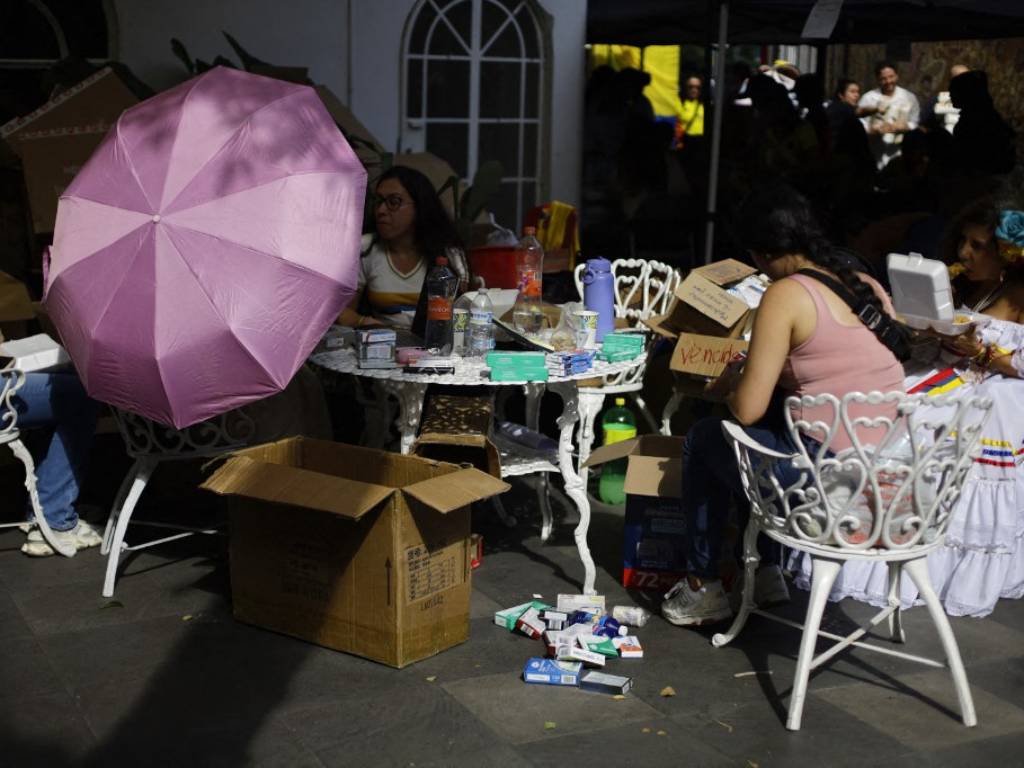Mujeres voluntarias reunidas comiendo alimentos durante un receso en la zona de acopio de medicinas.