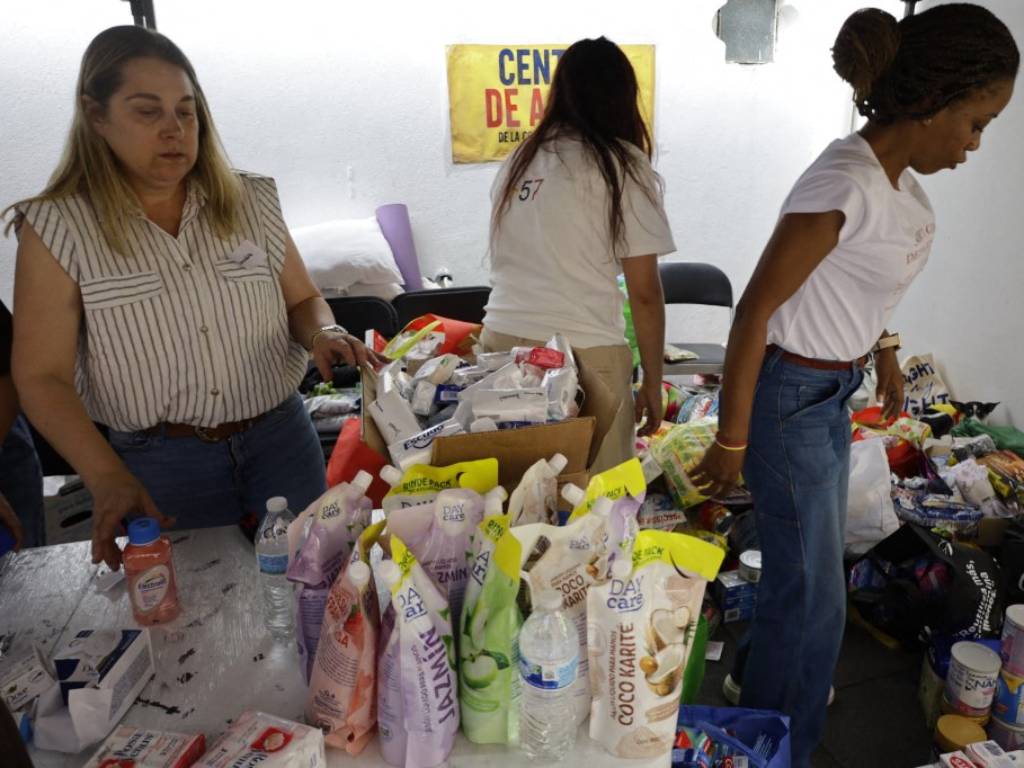 Envoltorios y latas de alimentos empacados organizados en cajas de cartón dentro del punto de recolección.