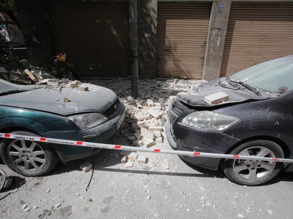 Automóvil estacionado en la calle con destrozos provocados por la caída de escombros tras el terremoto.