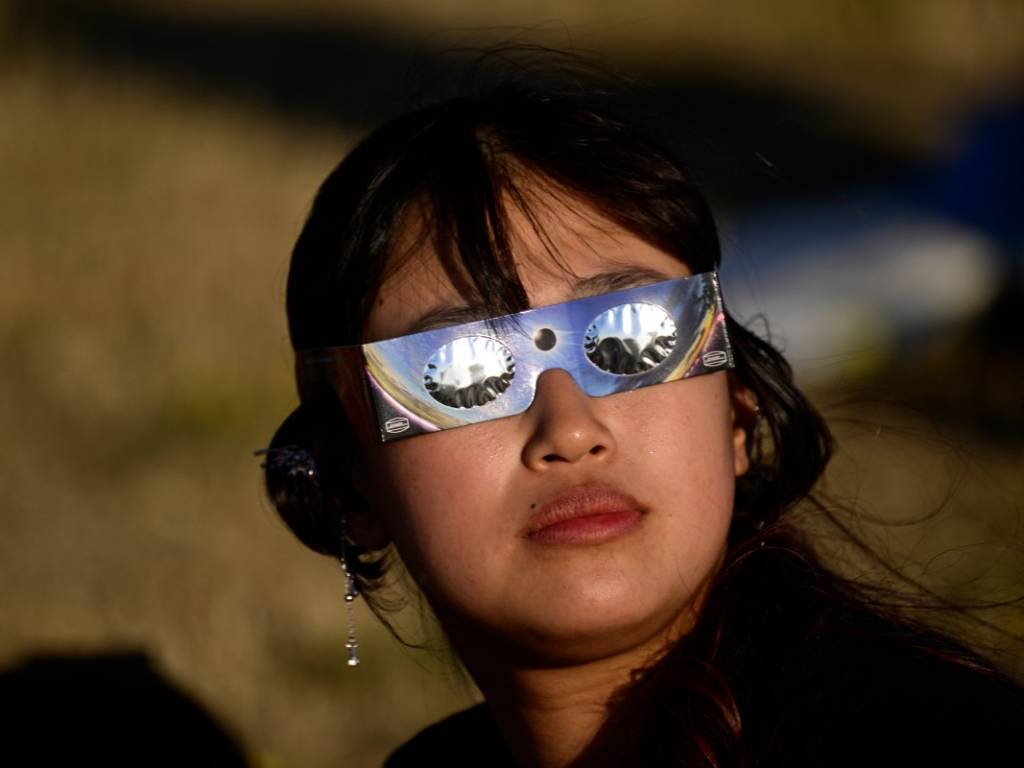Un grupo de personas observa el eclipse solar parcial desde lo alto del parque paisajístico Halde Hoheward en Herten.