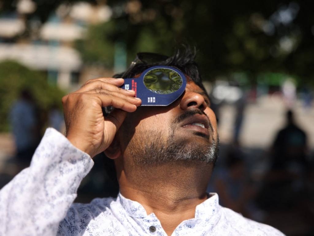 n hombre se prepara para observar el eclipse solar con gafas de protección en el puente de Piedra de Zaragoza.