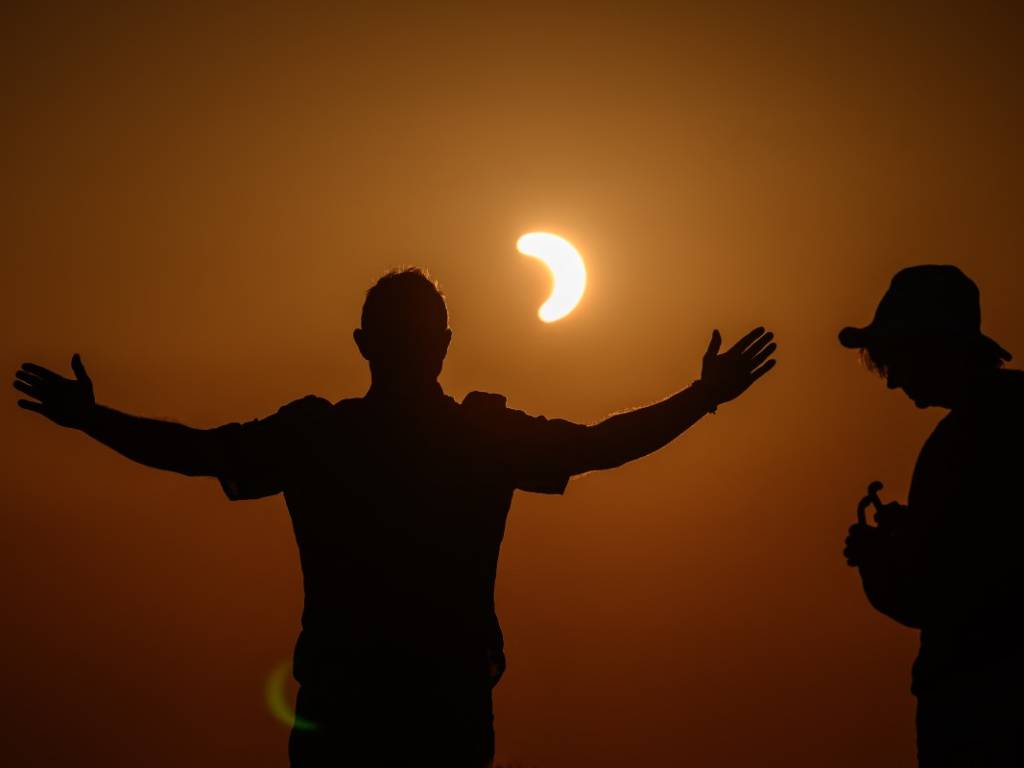 Un grupo de personas observa el eclipse solar parcial desde la cumbre del pico Chasseral en Suiza.