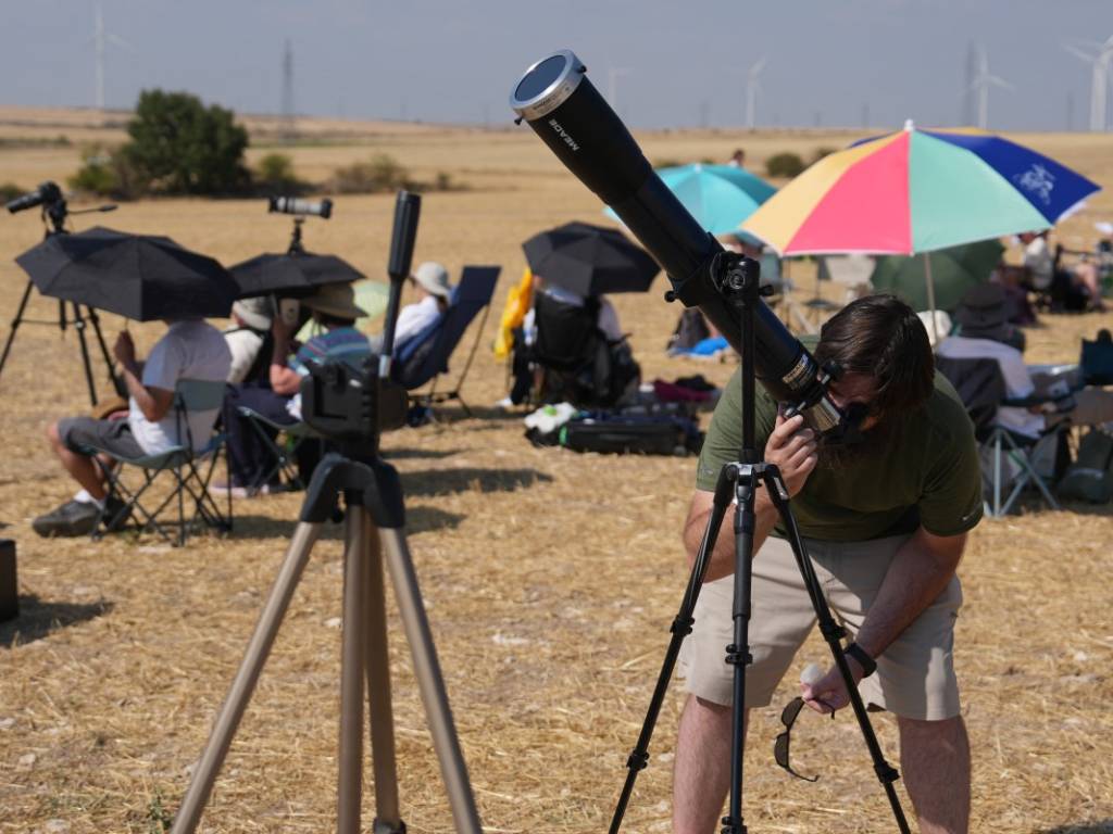 Grupo de aficionados a la astronomía ajustando telescopios y equipos de observación en Lodoso para ver el eclipse solar.