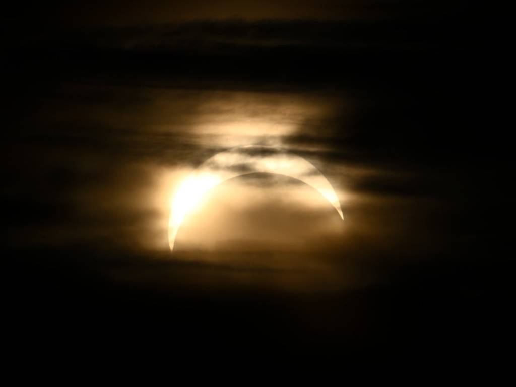 Observatorielunden de Estocolmo observan un eclipse parcial de sol en el cielo sobre la ciudad.