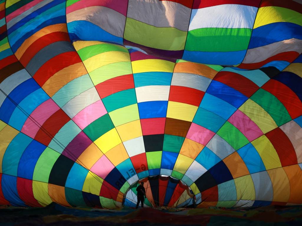 Vista desde el interior de la lona de un globo gigante con un patrón geométrico de parches coloridos.