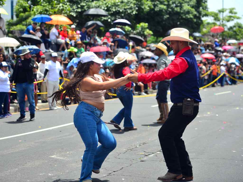 Un miembro del desfile hípico baila alegre con una espectadora.