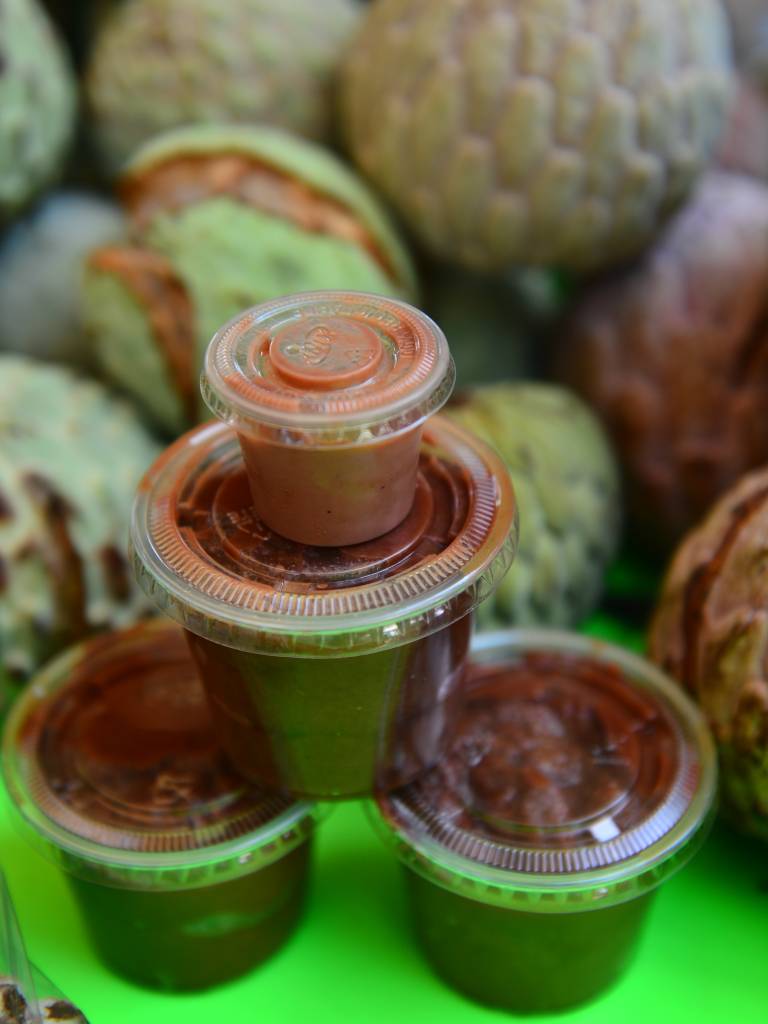 Frascos de cristal llenos de jalea de anona artesanal expuestos en un puesto.