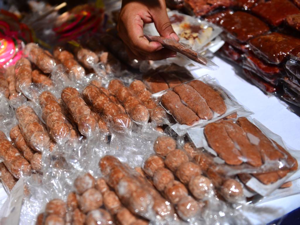 Exhibición de diversos dulces artesanales de colores y sabores tradicionales sobre la mesa.