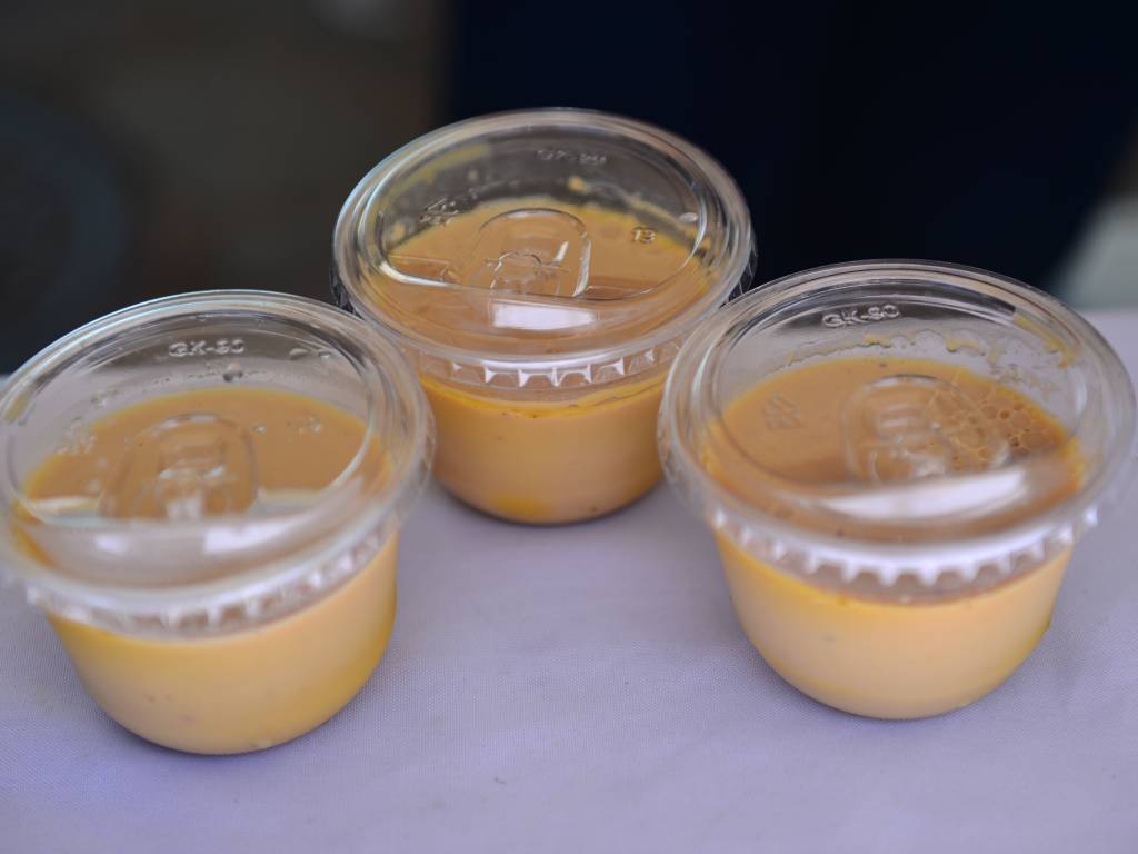 Porción de flan bañado en caramelo y servido en un plato desechable.