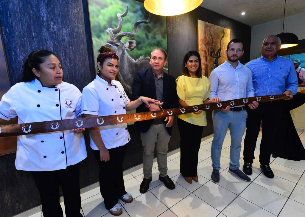 Personas cortando la cinta inaugural en la entrada de Restaurante Kudú.