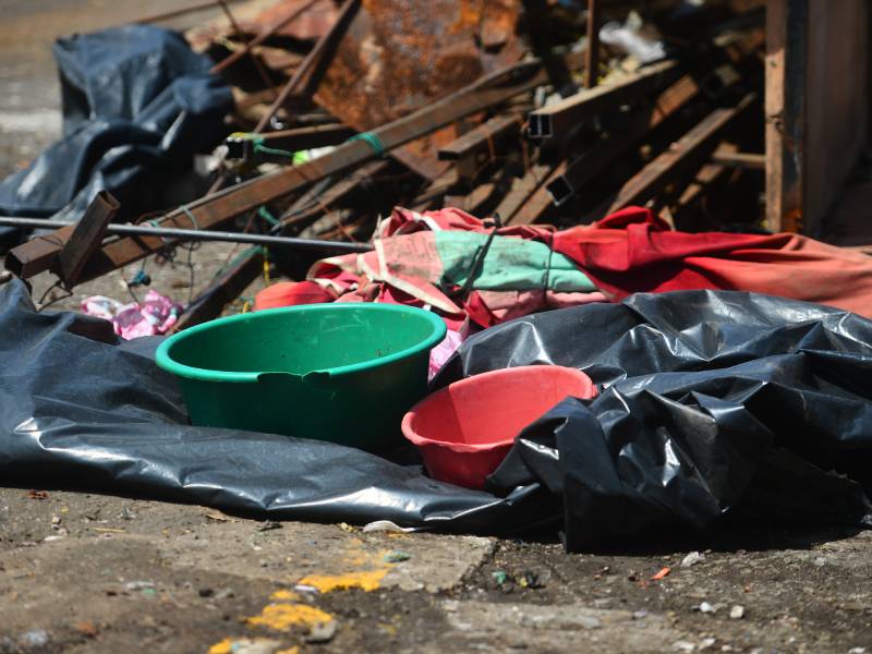 Restos de plásticos, mantas y sombrillas improvisadas cuelgan abandonados sobre los armazones de las ventas callejeras.