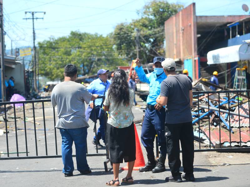 Agentes del Cuerpo de Agentes Metropolitanos brindan indicaciones sobre las vías alternas a transeúntes en una zona acordonada.