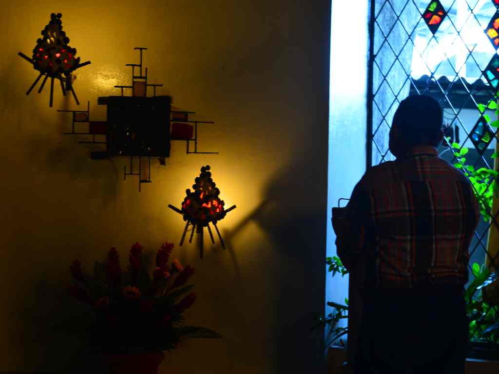 Persona arrodillada en silencio frente al altar del Santísimo Sacramento iluminado en el interior de la iglesia.