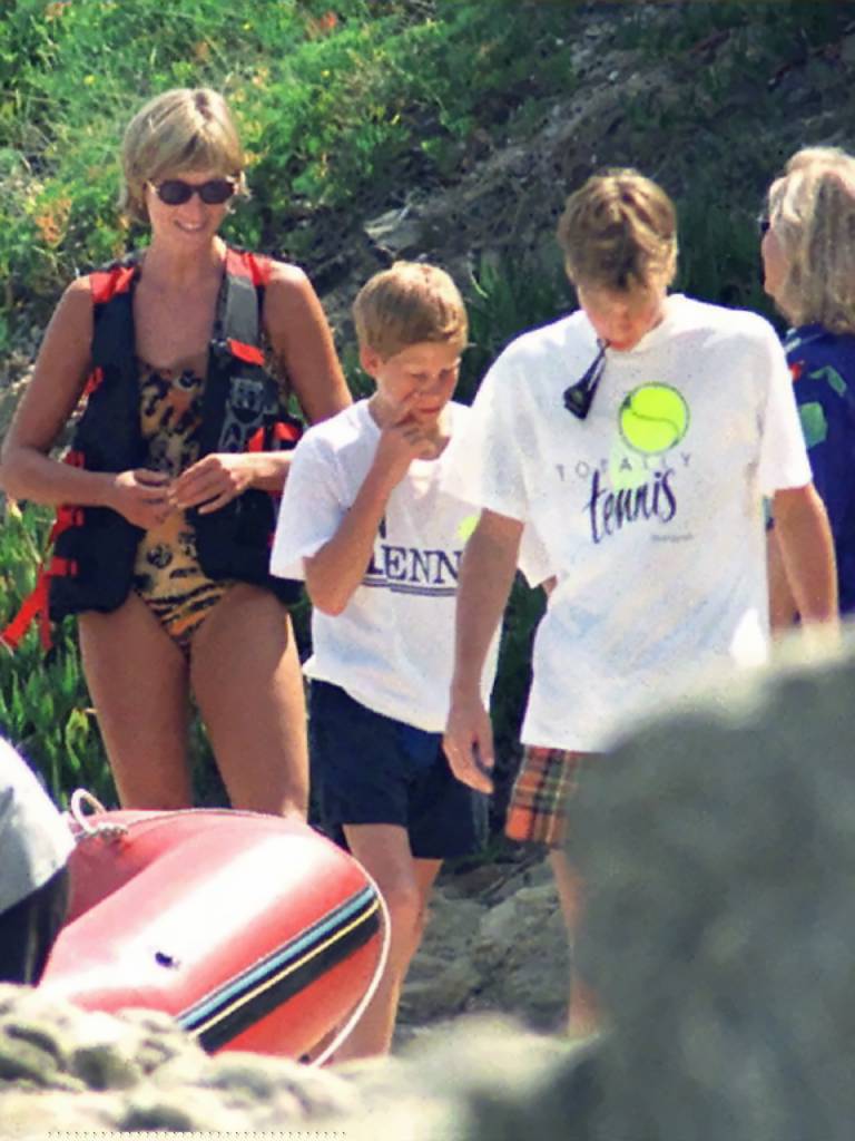 Lady Di sonriendo y jugando junto a los jóvenes príncipes William y Harry a la orilla del mar en Francia.