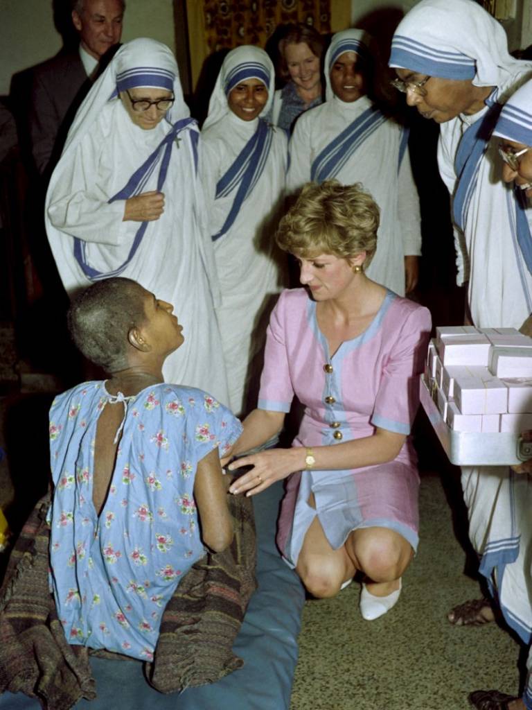La princesa Diana de Gales agachada junto al lecho de un paciente en el hogar Misioneras de la Caridad en Calcuta.