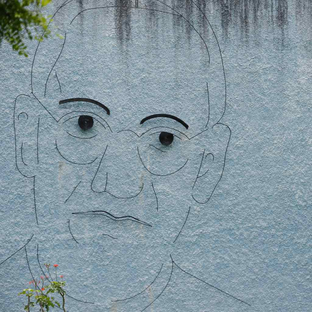 Rostro lineal de San Romero formado por láminas de metal en un muro de la Universidad de El Salvador.