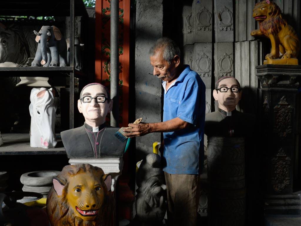 Un artesano retoca con esmero uno de los tantos bustos de San Romero en su taller.