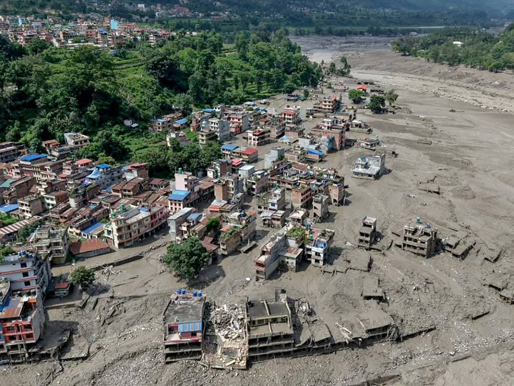 Múltiples viviendas ubicadas a orillas del río permanecen sumergidas por un denso torrente de lodo tras las fuertes riadas.