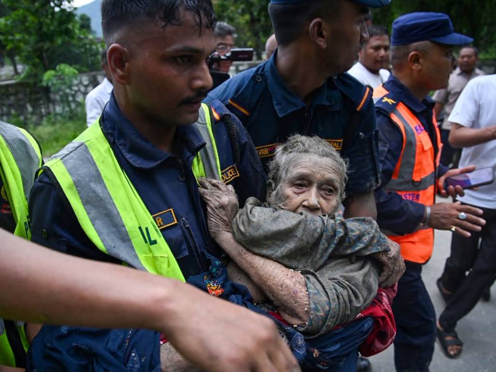 Socorristas evacuando a una persona afectada por las inundaciones entre el lodo en Devghat, Nepal.