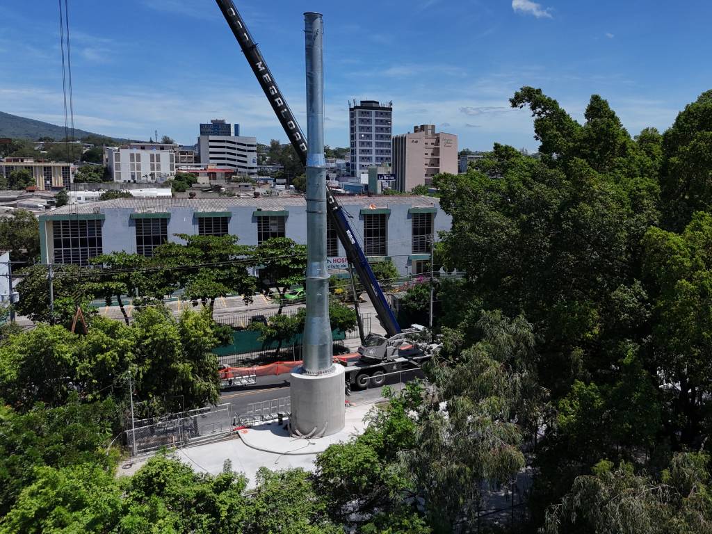 Conos de señalización y personal de tránsito gestionando el flujo vehicular junto a la zona de obras.