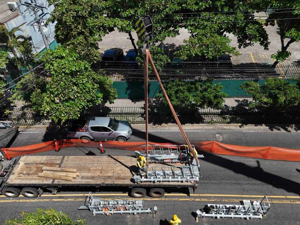 Maquinaria pesada operando en la vía delimitada por barreras de seguridad entre la 25ª Avenida y Diagonal Universitaria.