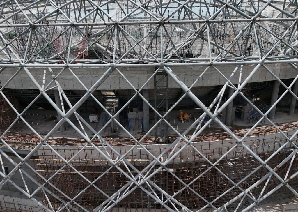 Toma en ángulo exterior que muestra los avances en el montaje de la fachada del estadio, destacando el marco de barras metálicas entrelazadas y los niveles superiores de la obra.
