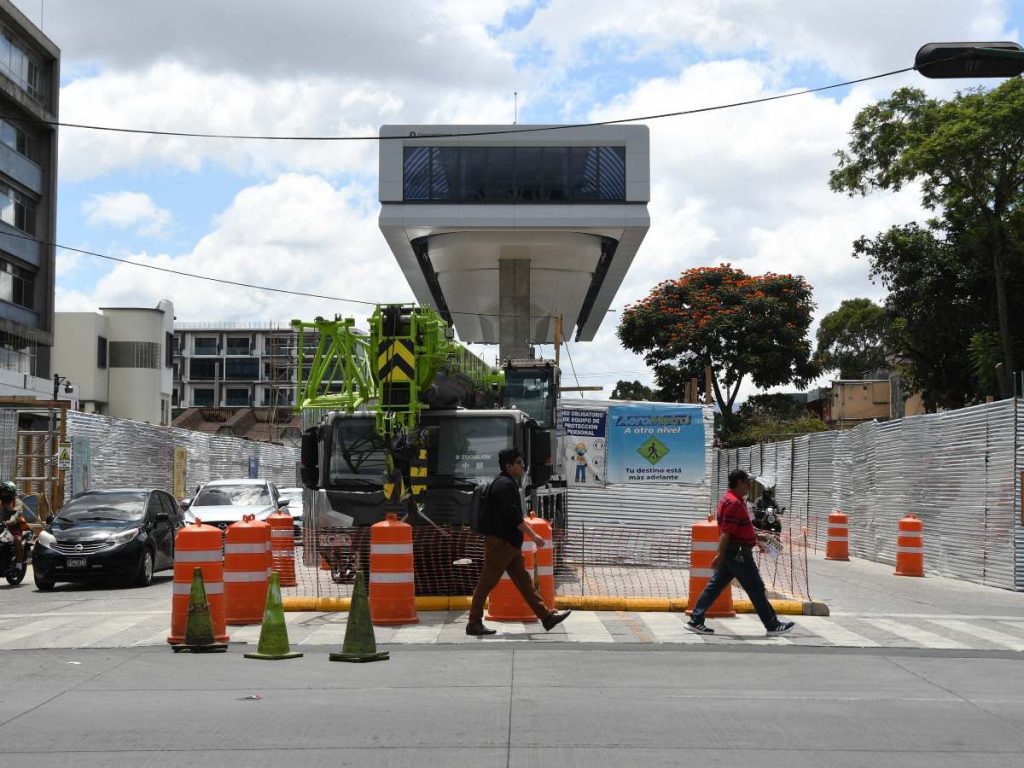 Personas caminan frente a la construcción del AeroMetro este martes, en una área de la zona 9 en Ciudad de Guatemala (Guatemala). 