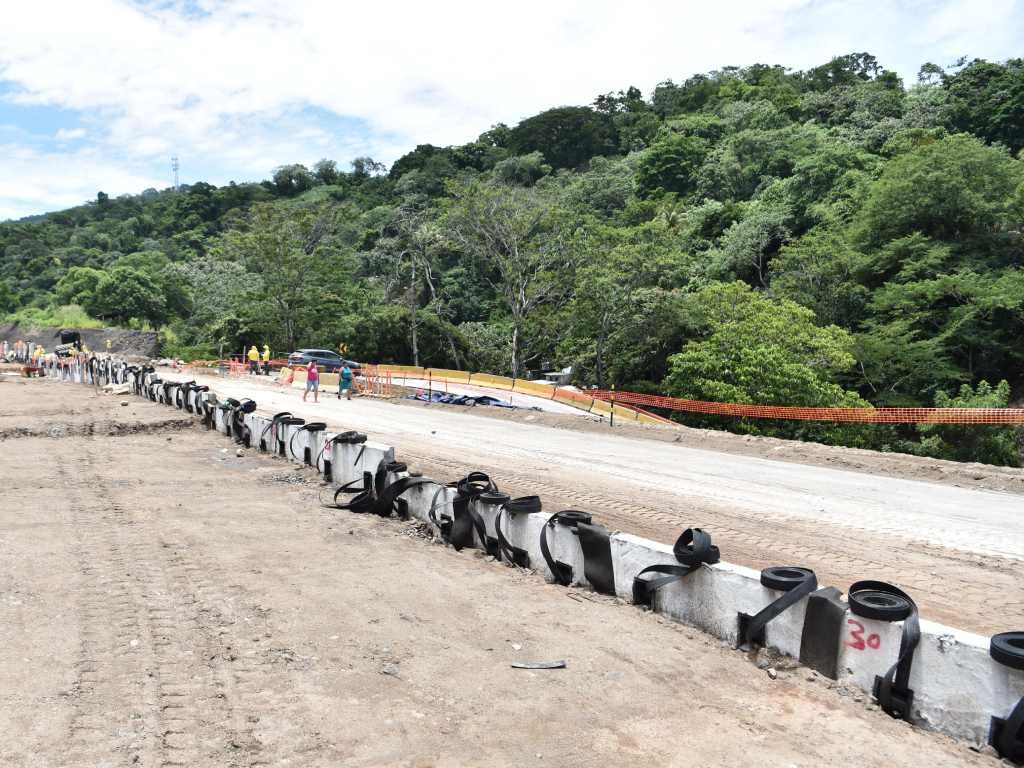 Vista lateral de una nueva sección de la vía con barreras de seguridad y señalización.