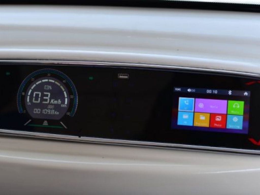 Panel digital de control del carro eléctrico mostrando la velocidad y opciones de conectividad para el viaje.