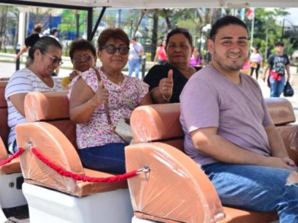 Turistas sonrientes disfrutan cómodamente de un recorrido guiado en vehículo eléctrico por la capital.