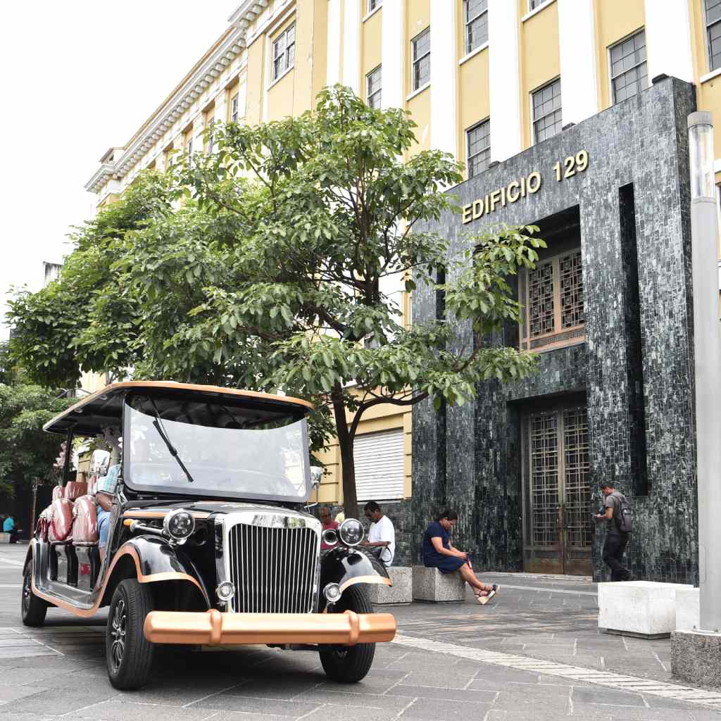 Vehículo estilo clásico recorre las calles recuperadas junto a emblemáticos edificios del centro histórico.