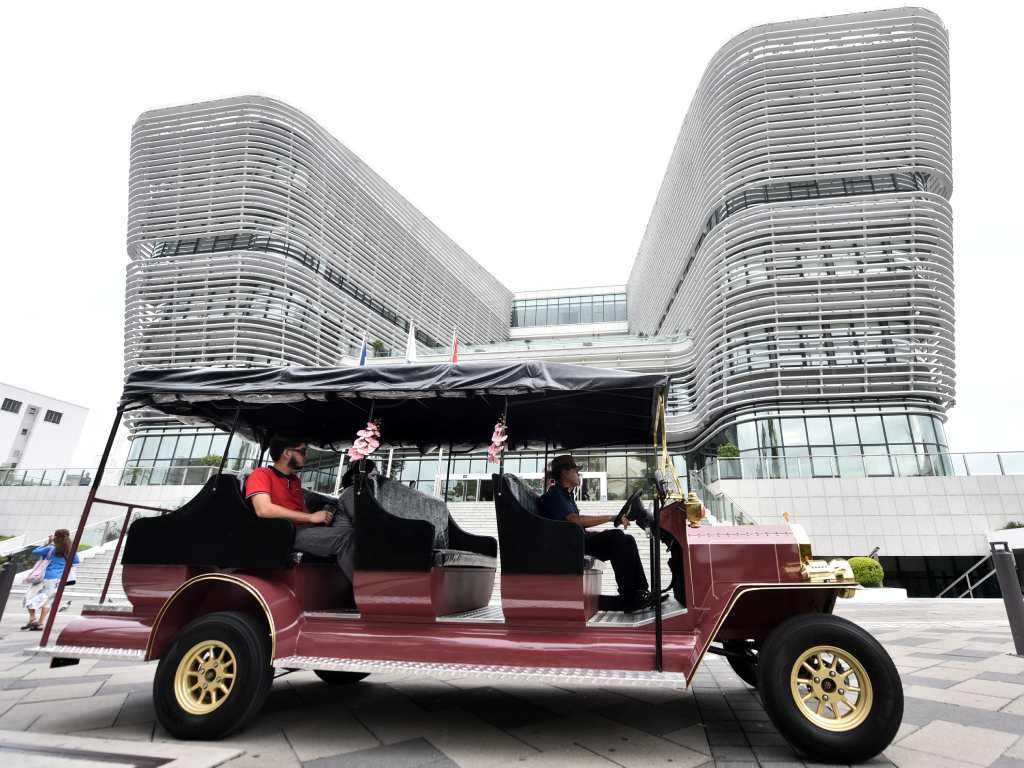 Carro turístico transita frente a la moderna estructura de la Biblioteca Nacional de El Salvador.