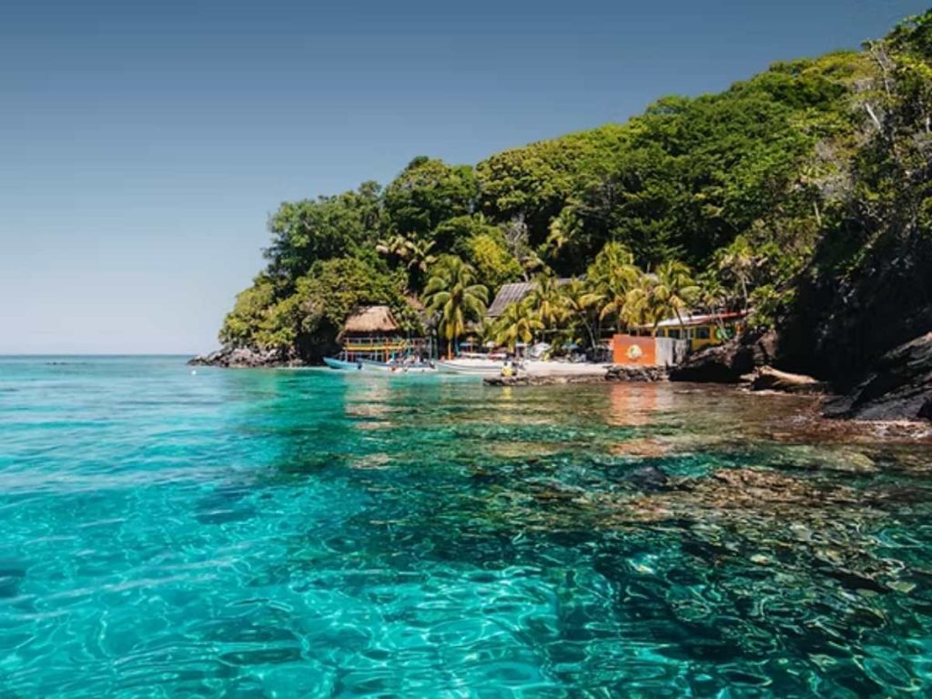 Cayos Cochinos destaca por sus aguas turquesa, playas de arena blanca y pequeños cayos rodeados por el mar Caribe.