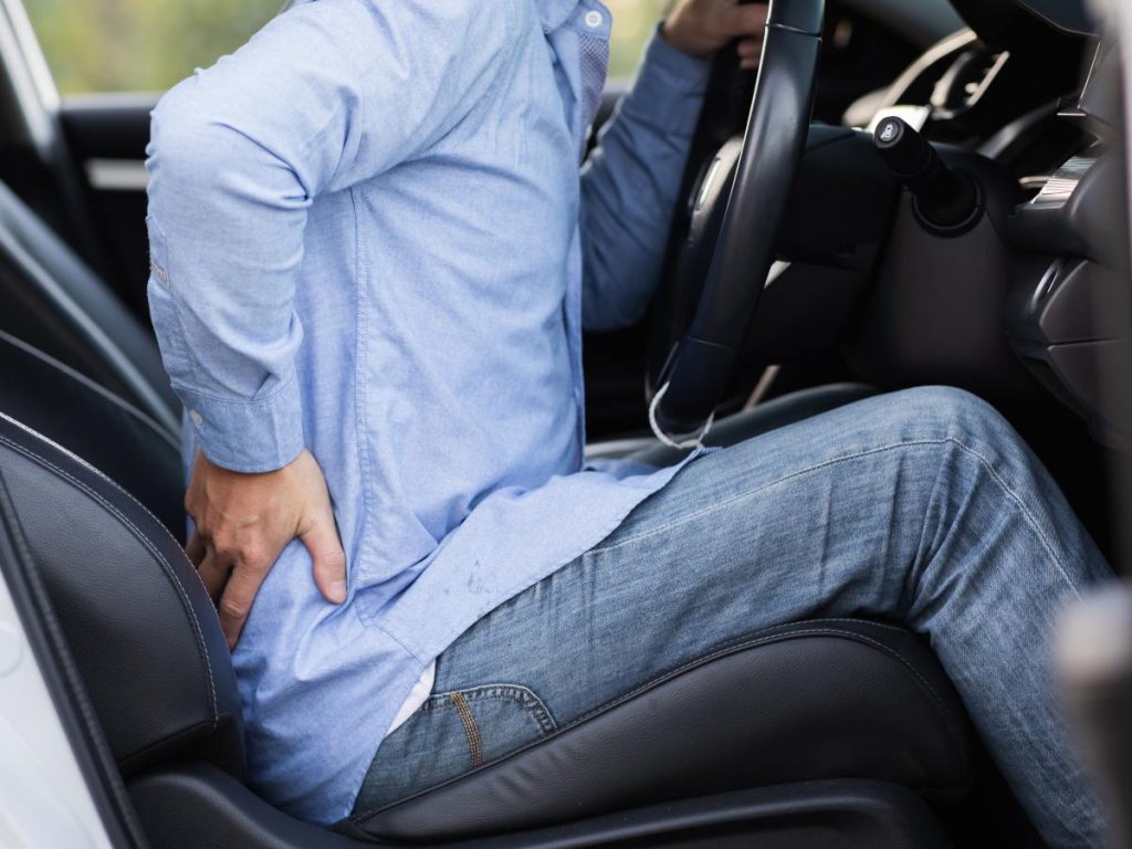 Cambiar de postura y hacer pausas frecuentes reduce la rigidez lumbar durante los trayectos largos en carro.